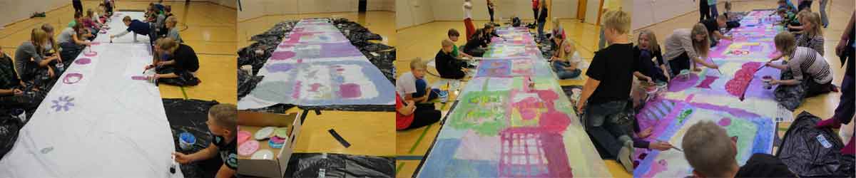 children are painting a long train on fabric